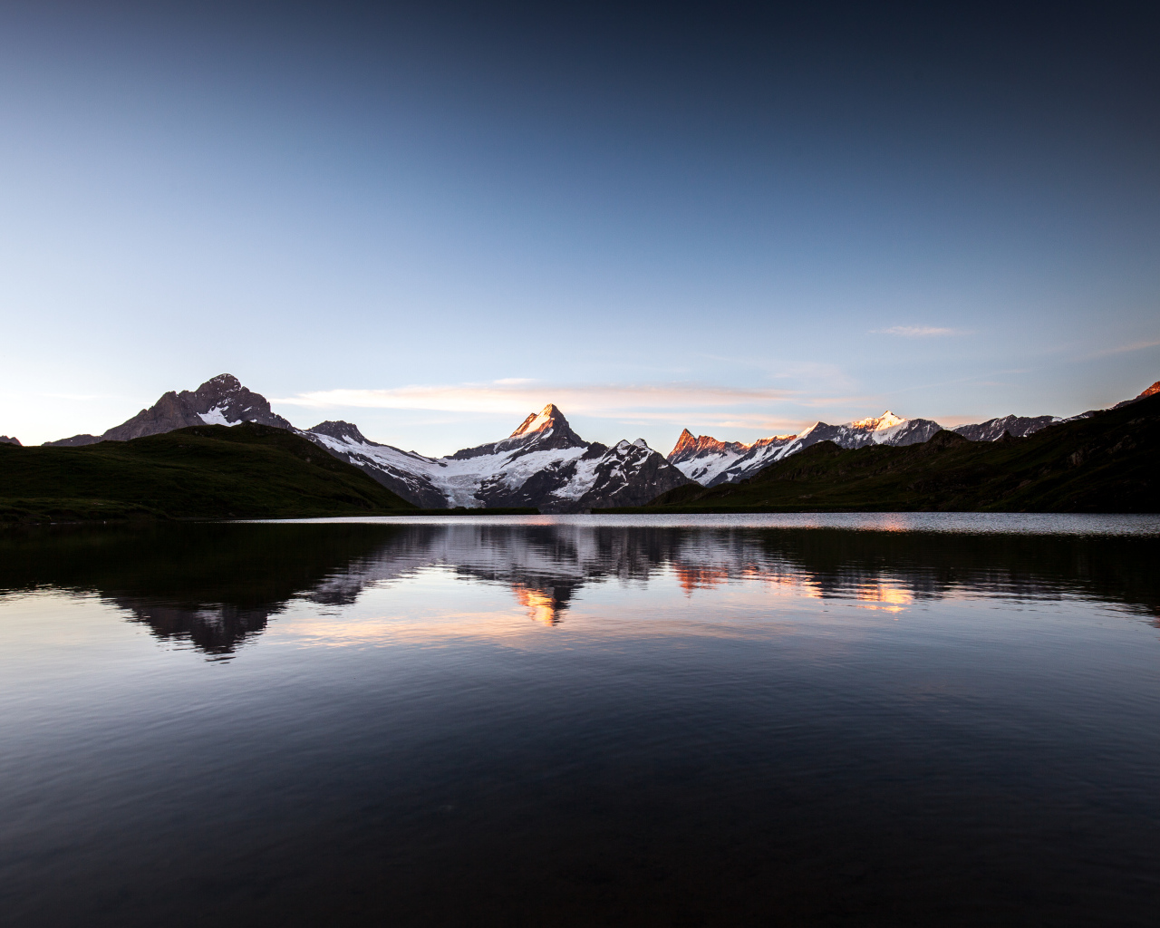 Спокойное горное озеро у заснеженных гор 