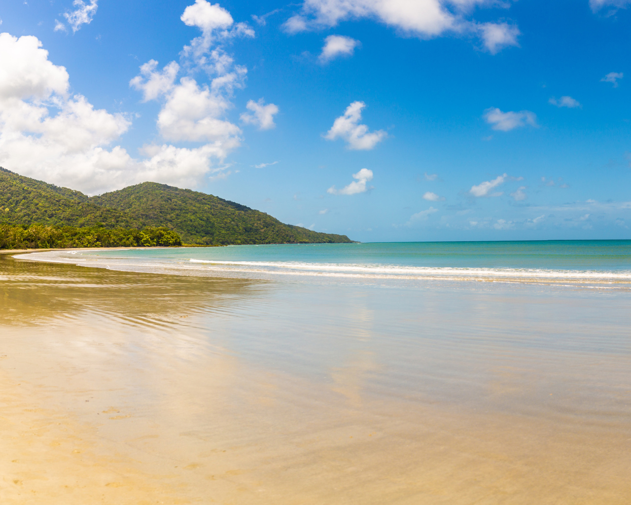 Спокойные волны на песке под красивым голубым небом