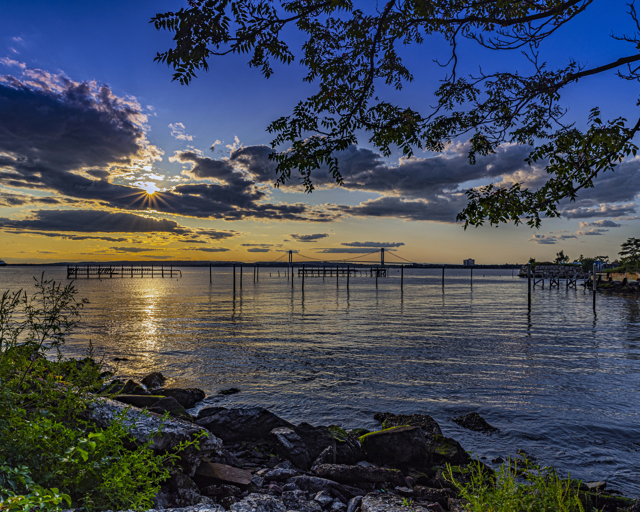 Солнце садится за тучи на горизонте в море