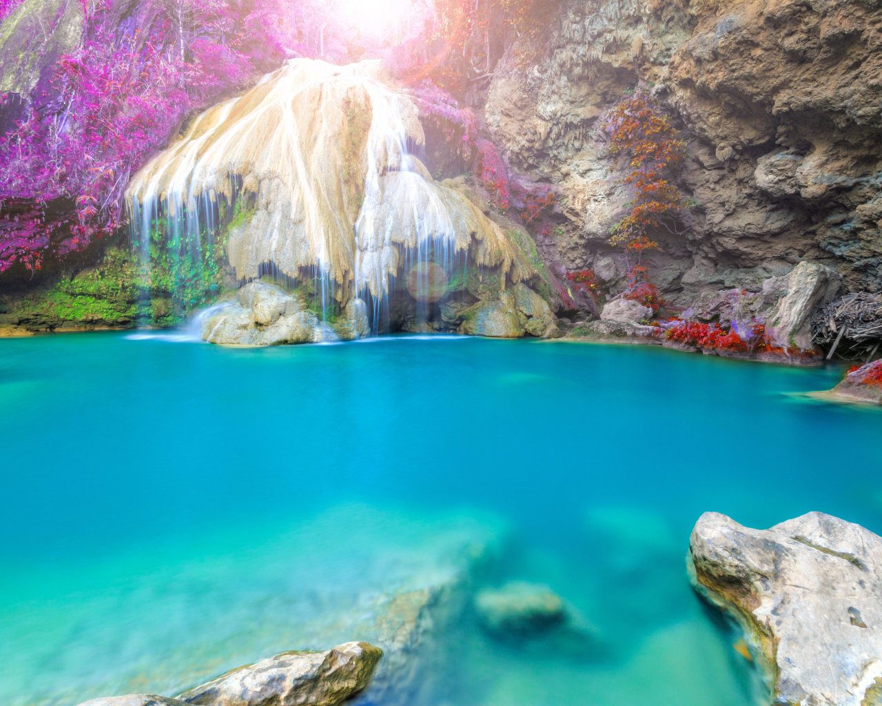 Водопад стекает по скале в голубую воду, Тайланд