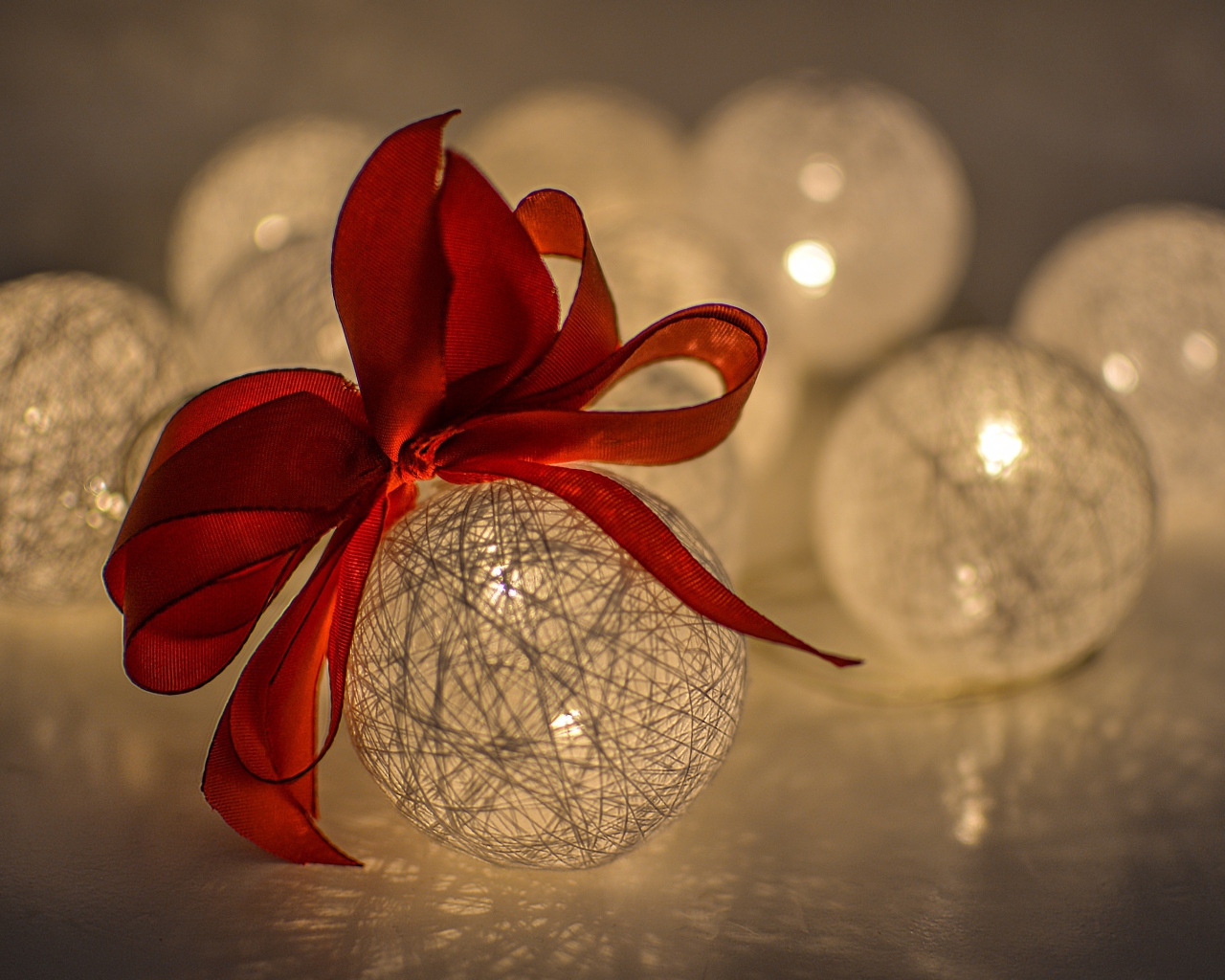 Красивый елочный шар с белых нитей с красным бантом