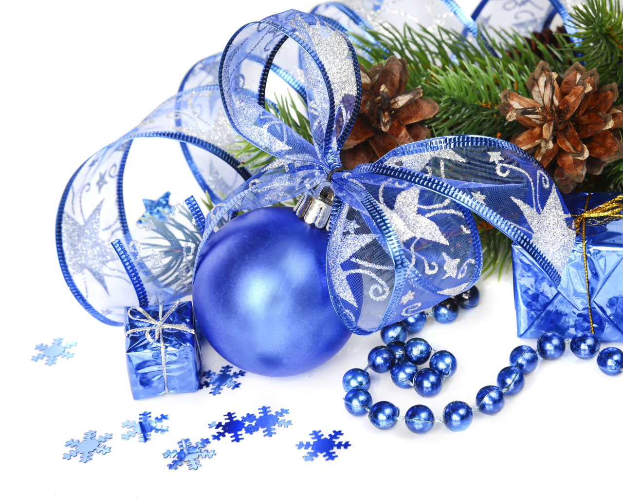 Красивый синий елочный шар с лентой на белом фоне с елочной веткой