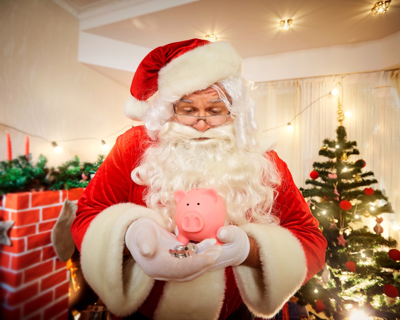 Дед Мороз со свиньей копилкой в руках у новогодней елки