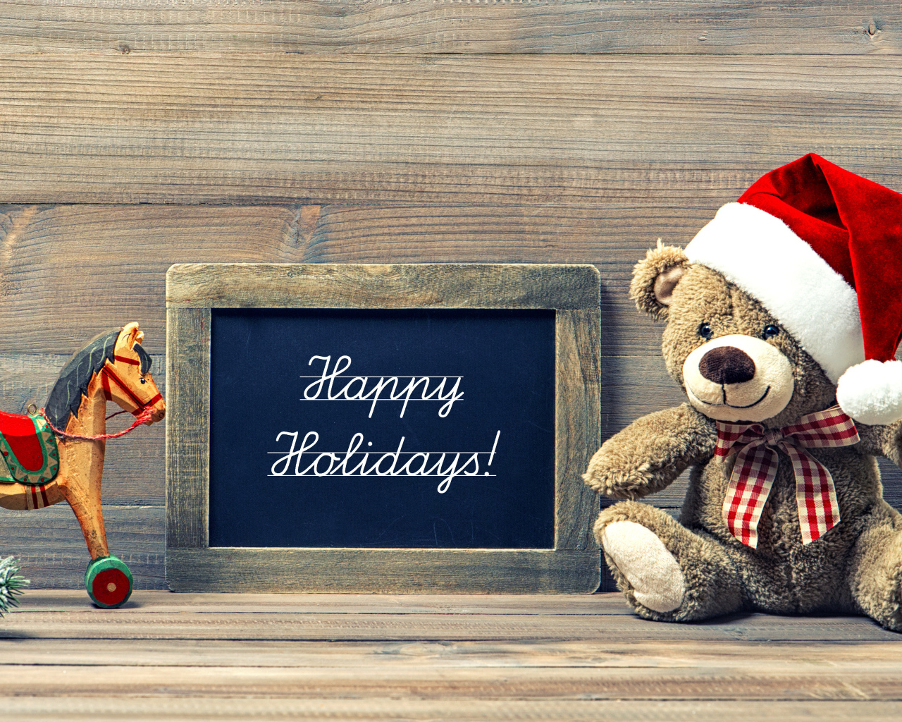 Игрушечный медвежонок Тедди в новогоднем колпаке на деревянном фоне с рамкой