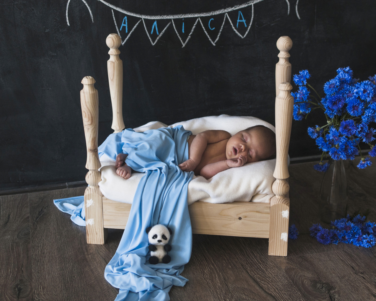 Грудной ребенок спит на деревянной кровати