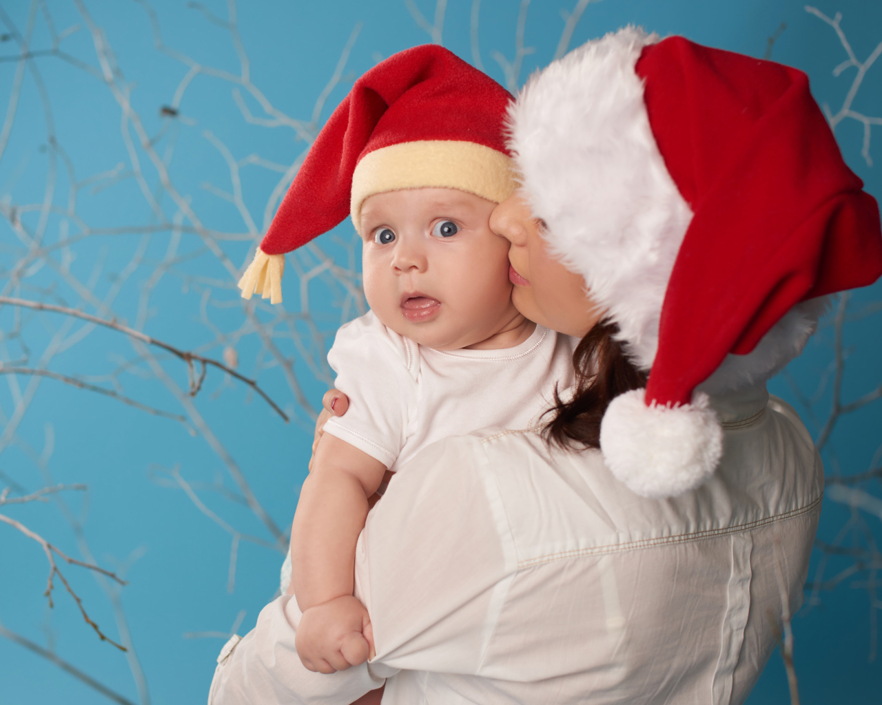 Маленький ребенок в новогоднем костюме на руках у мамы