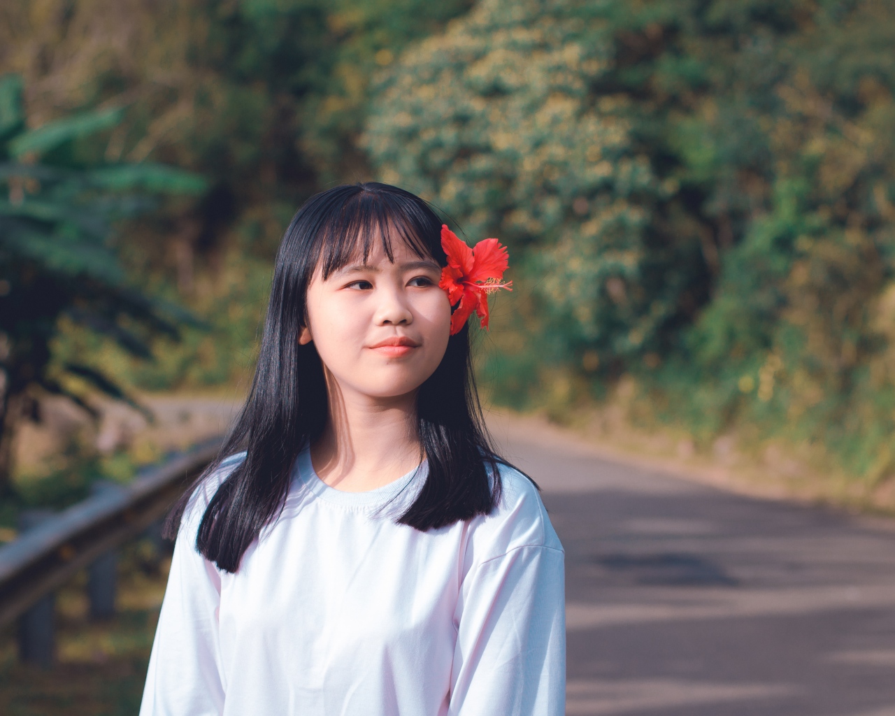 Девушка азиатка с красным цветком гибискуса в волосах