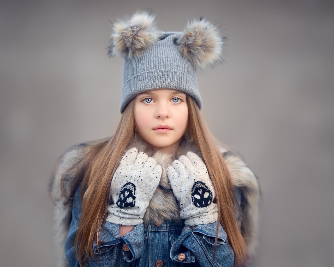 Красивая голубоглазая девочка в теплой шапке