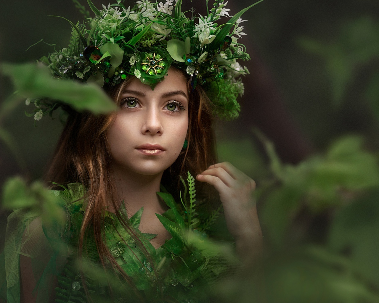 Красивая голубоглазая девочка с венком на голове у дерева