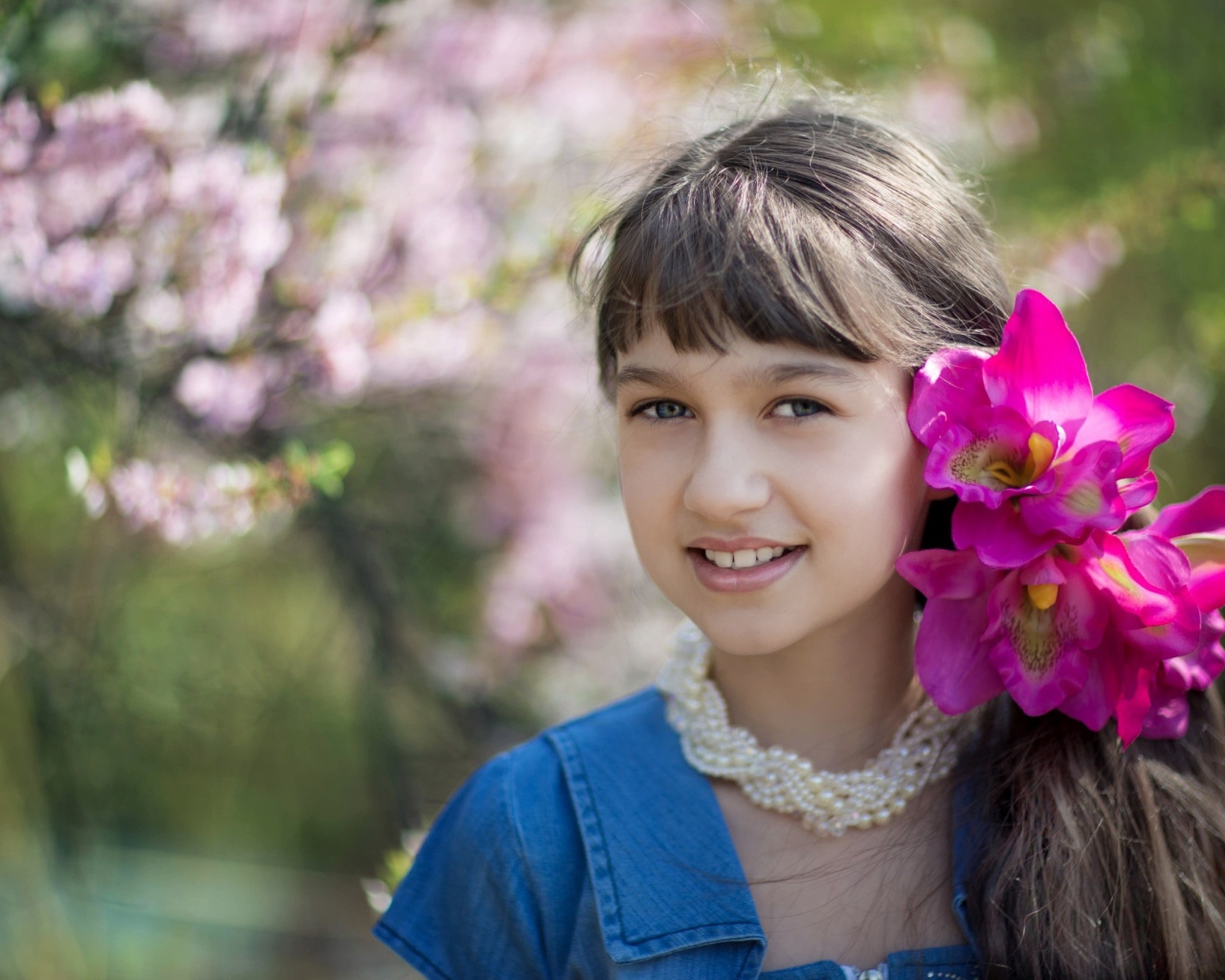 Красивая девочка с розовыми цветами в волосах