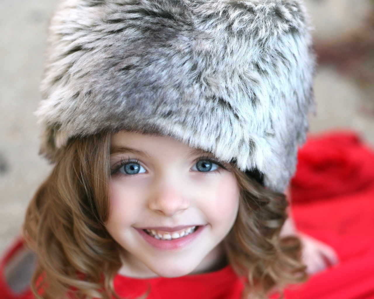 Красивая улыбающаяся девочка в меховой шапке