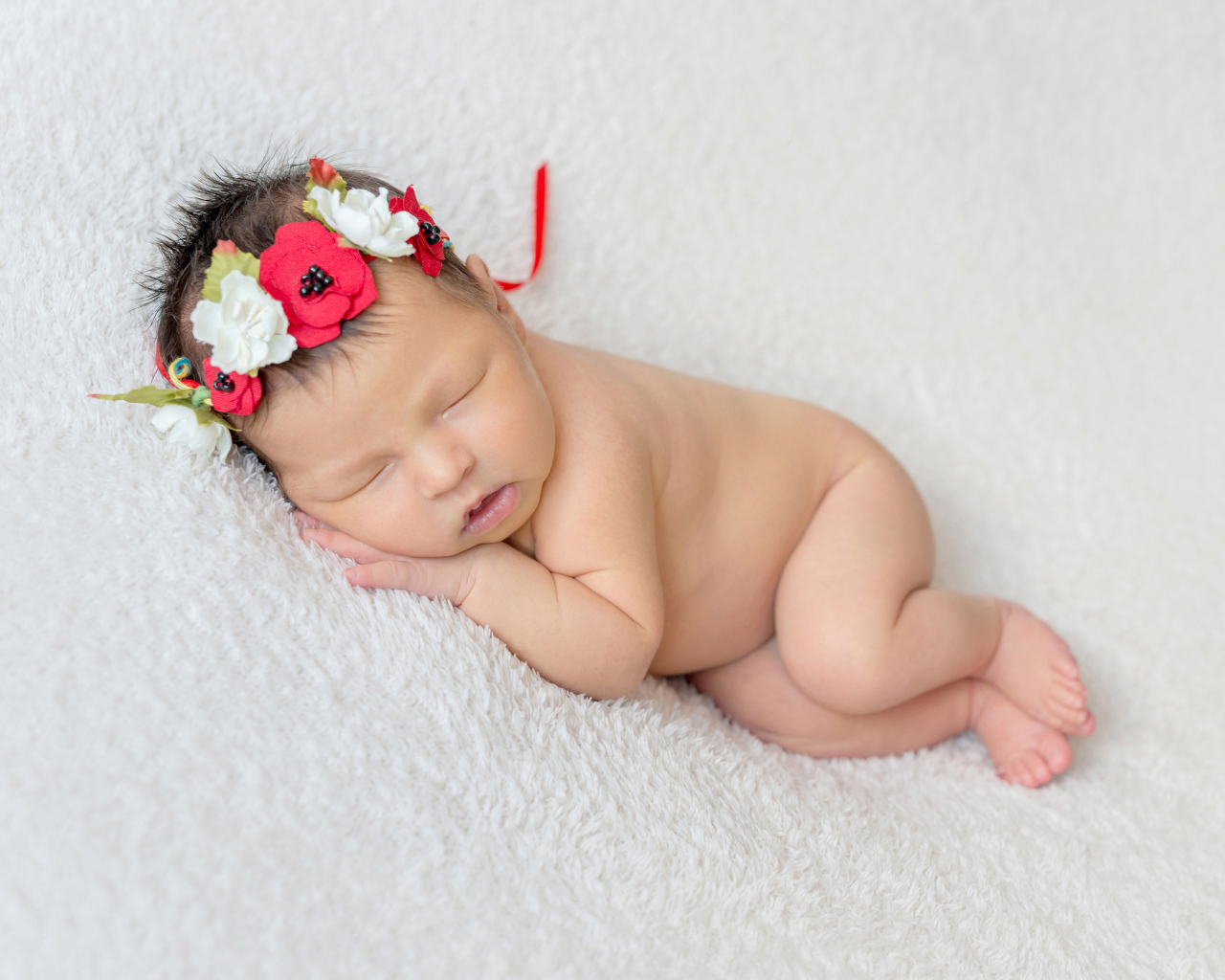 Грудная спящая девочка с венком на голове 