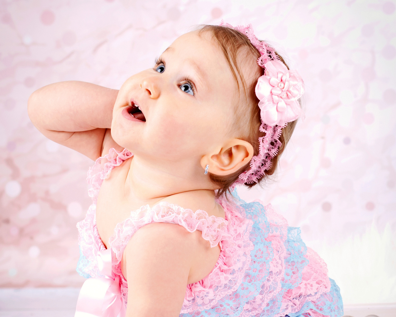 Милая голубоглазая девочка с розовой повязкой на голове