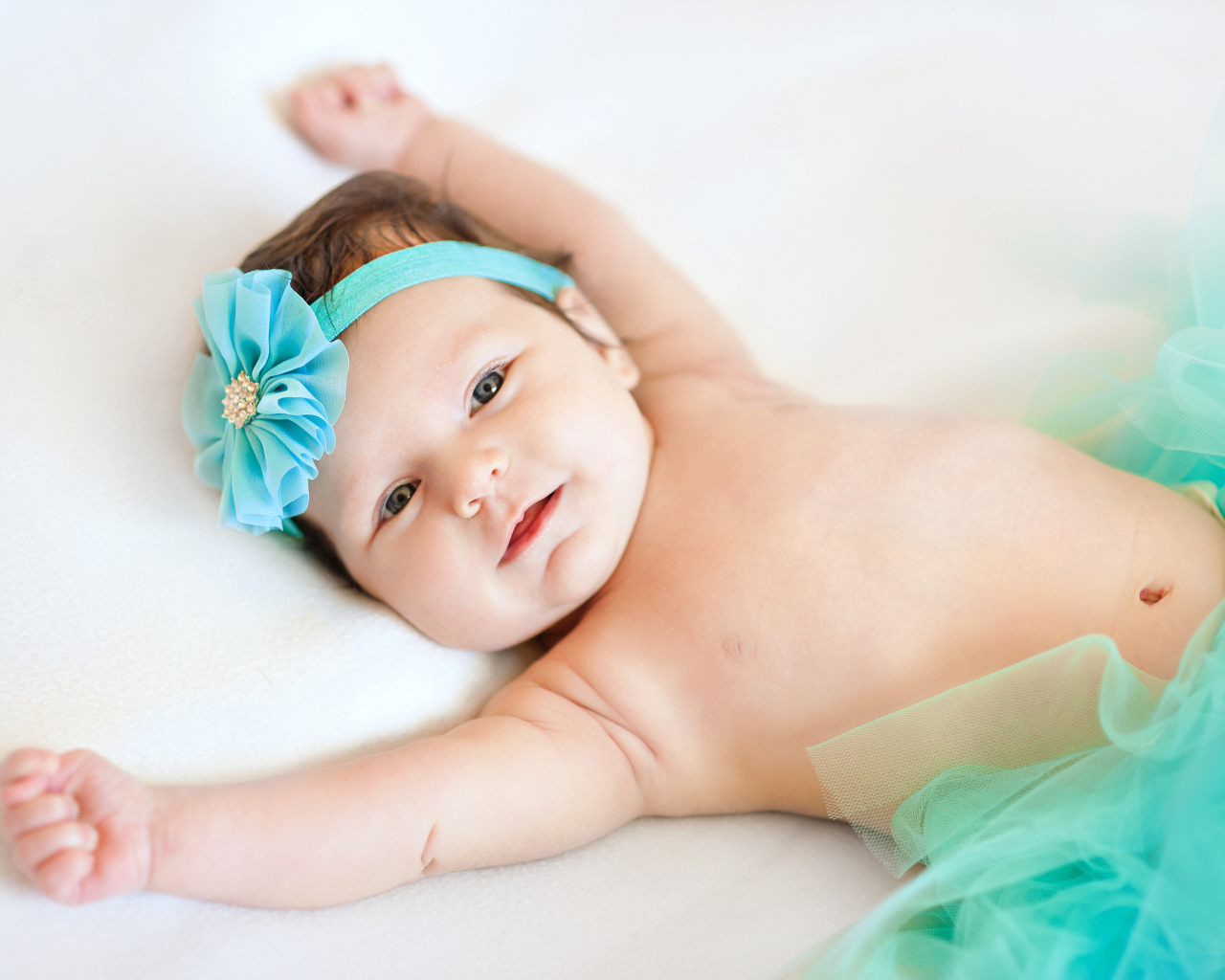 Милая маленькая девочка с повязкой с голубым цветком