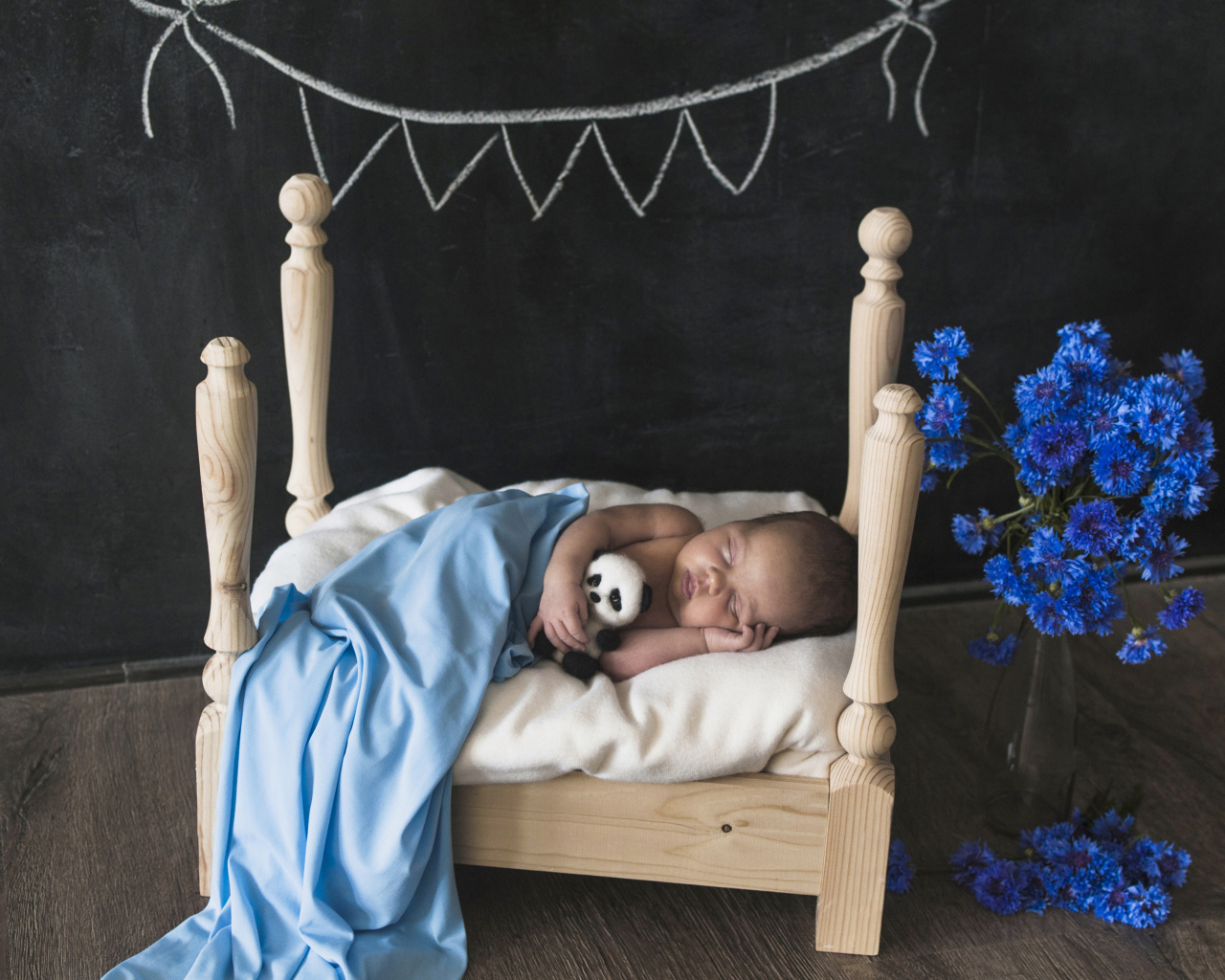 Маленький ребенок спит в деревянной кровати 