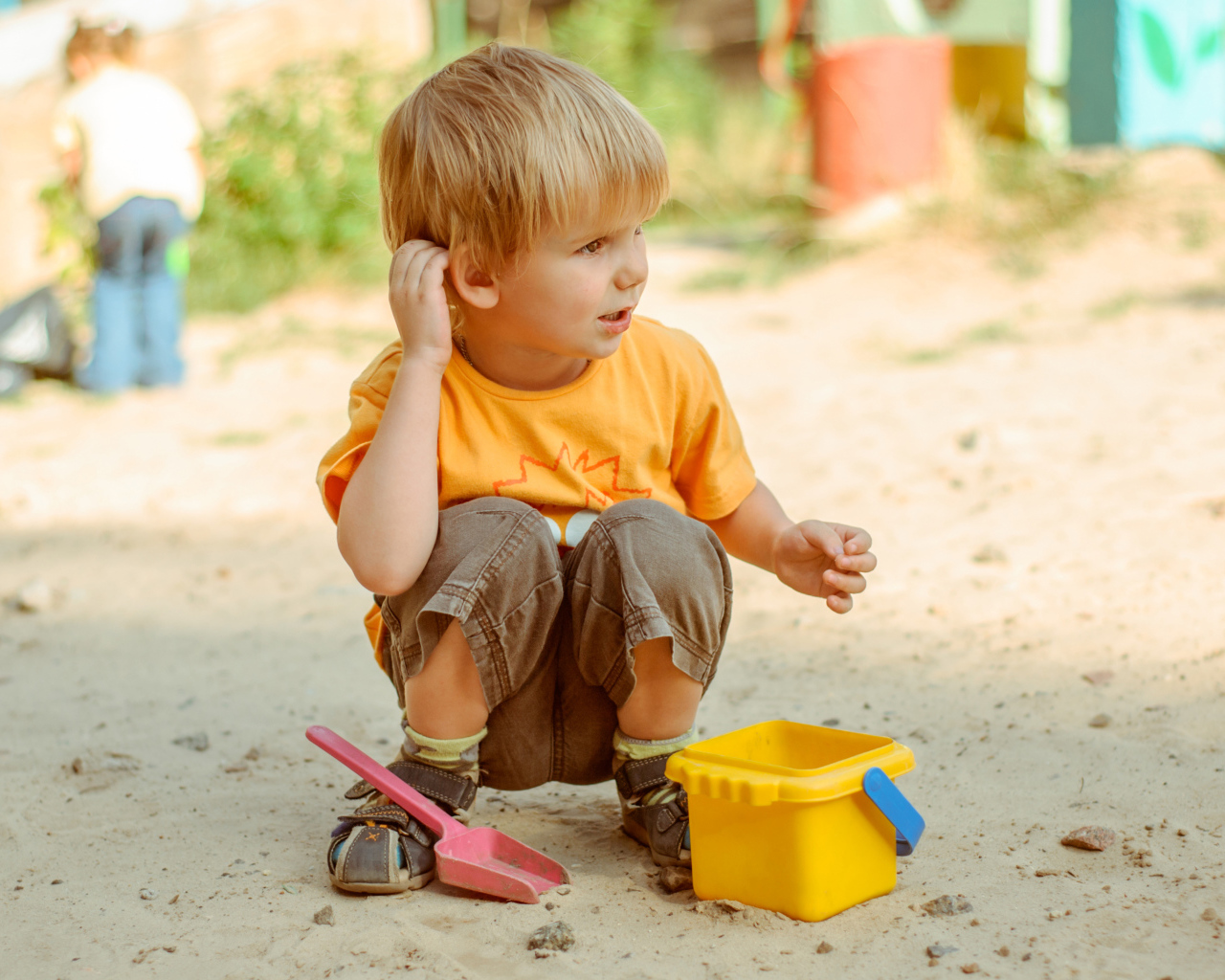 Маленький мальчик играет на песке 