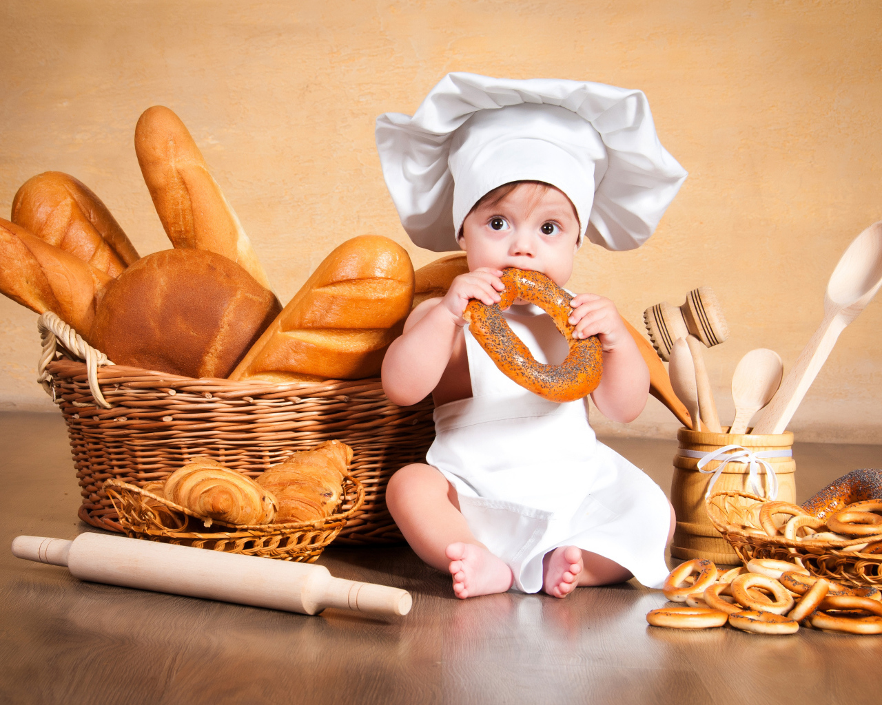 Маленький мальчик с хлебобулочными изделиями на столе 