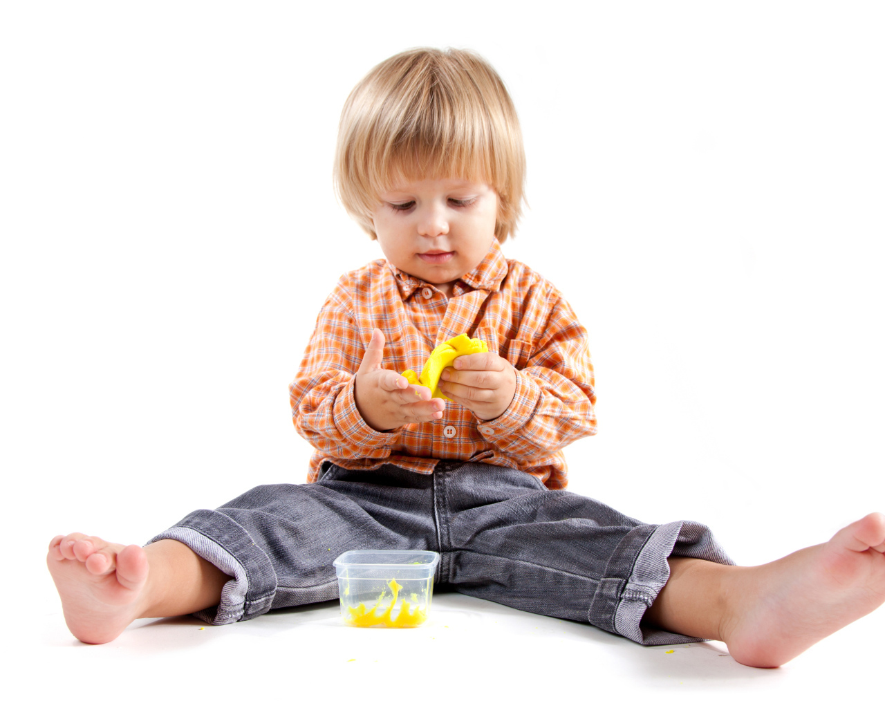 Маленький мальчик с игрушкой на белом фоне