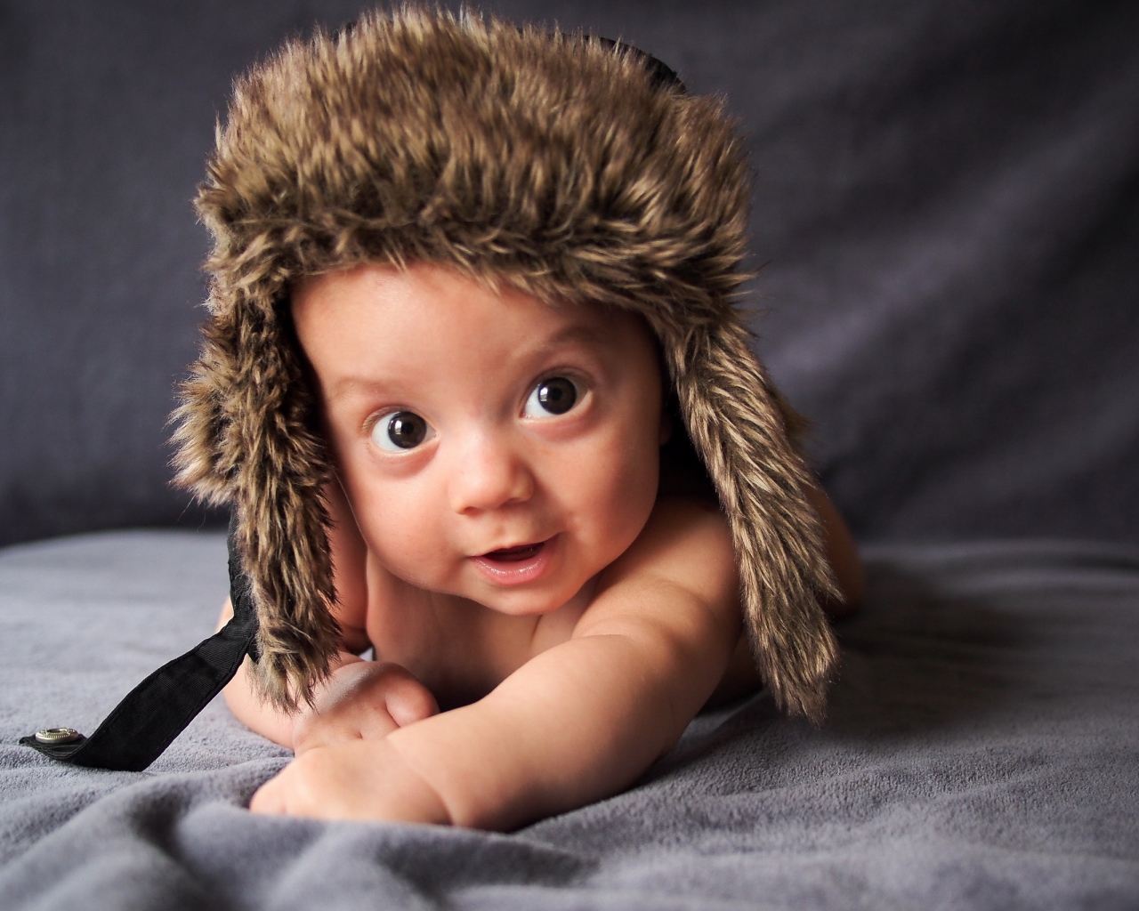 Маленький кареглазый ребенок в теплой шапке