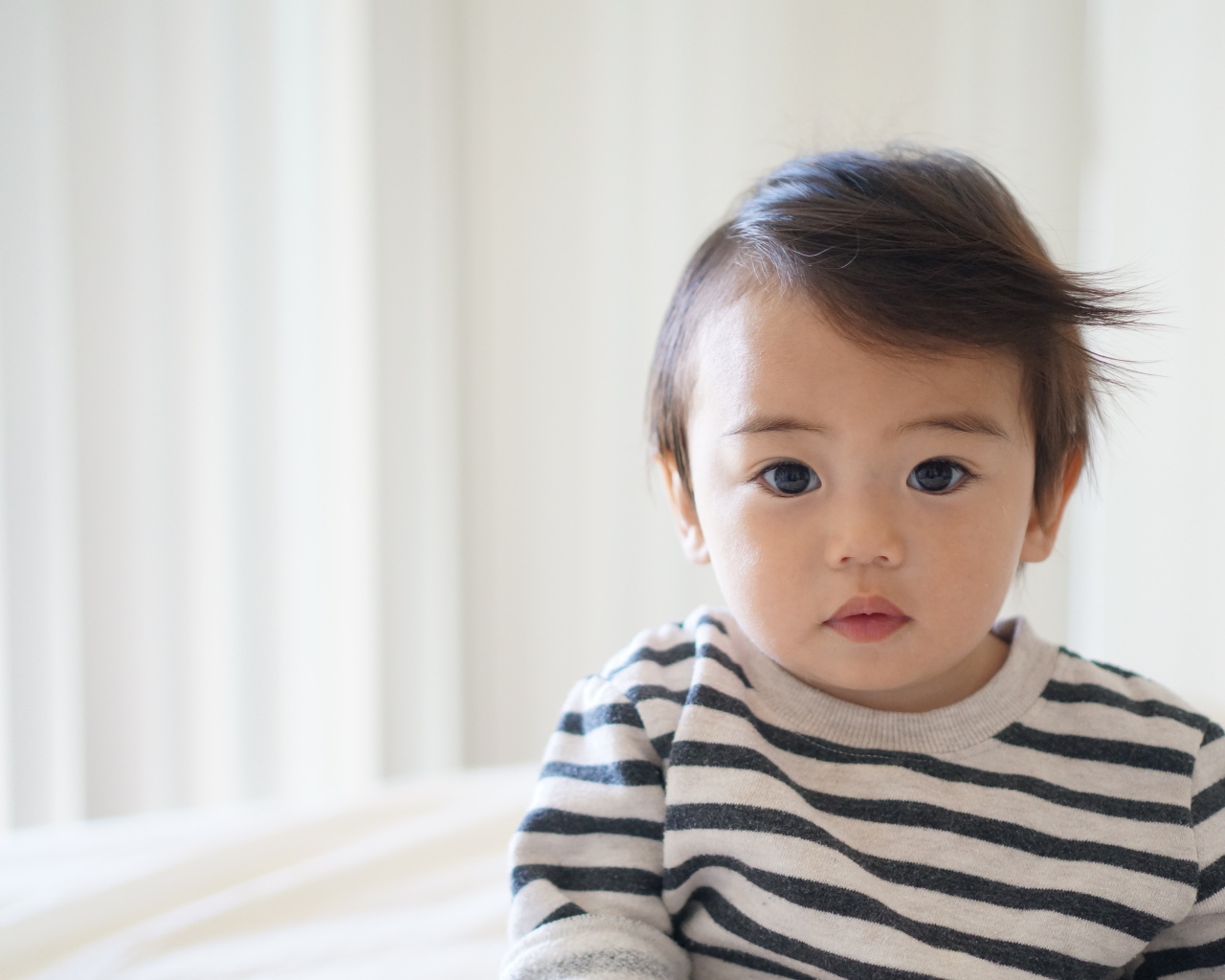 Маленький кареглазый мальчик в полосатом свитере