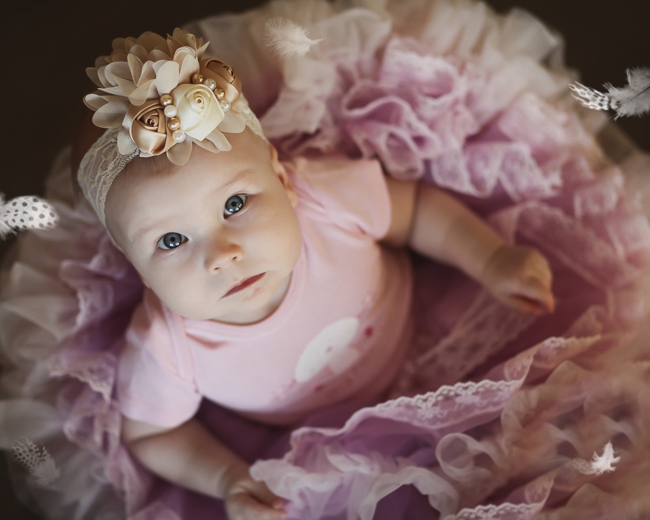 Маленькая милая девочка в пышном платье с повязкой на голове
