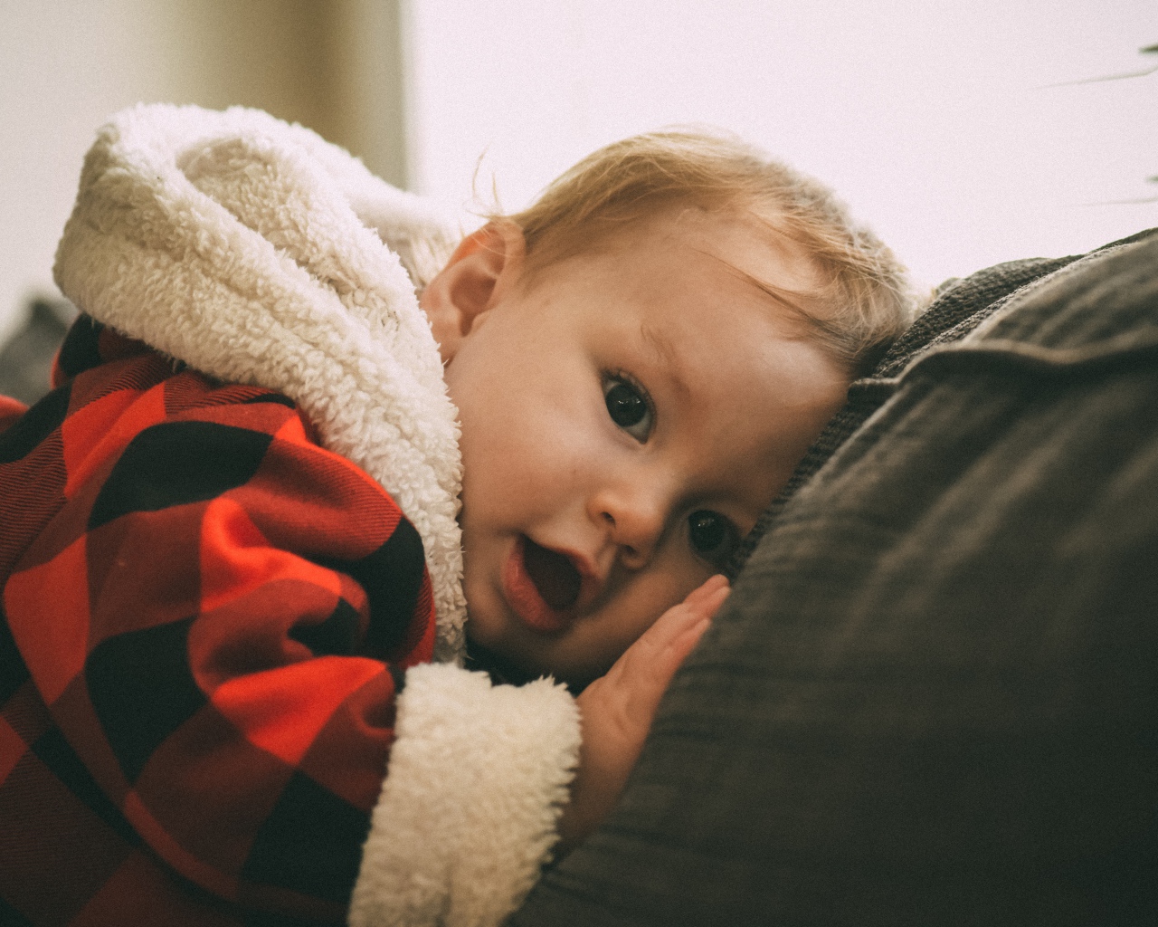 Маленький забавный малыш лежит на диване