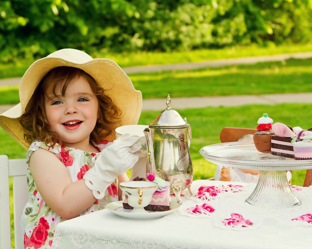 Маленькая девочка пьет чай на природе