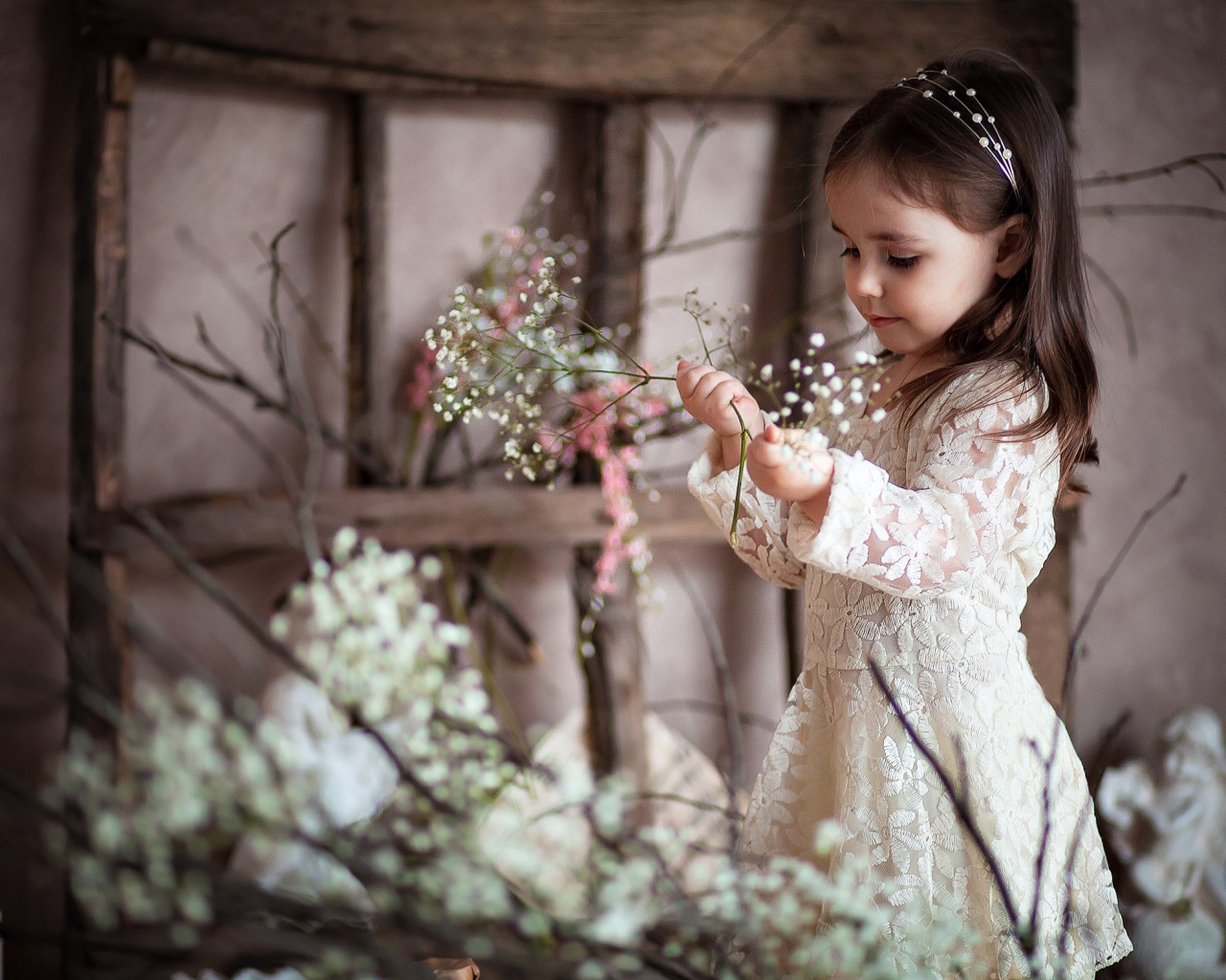 Маленькая девочка в красивом платье с белыми цветами в руке