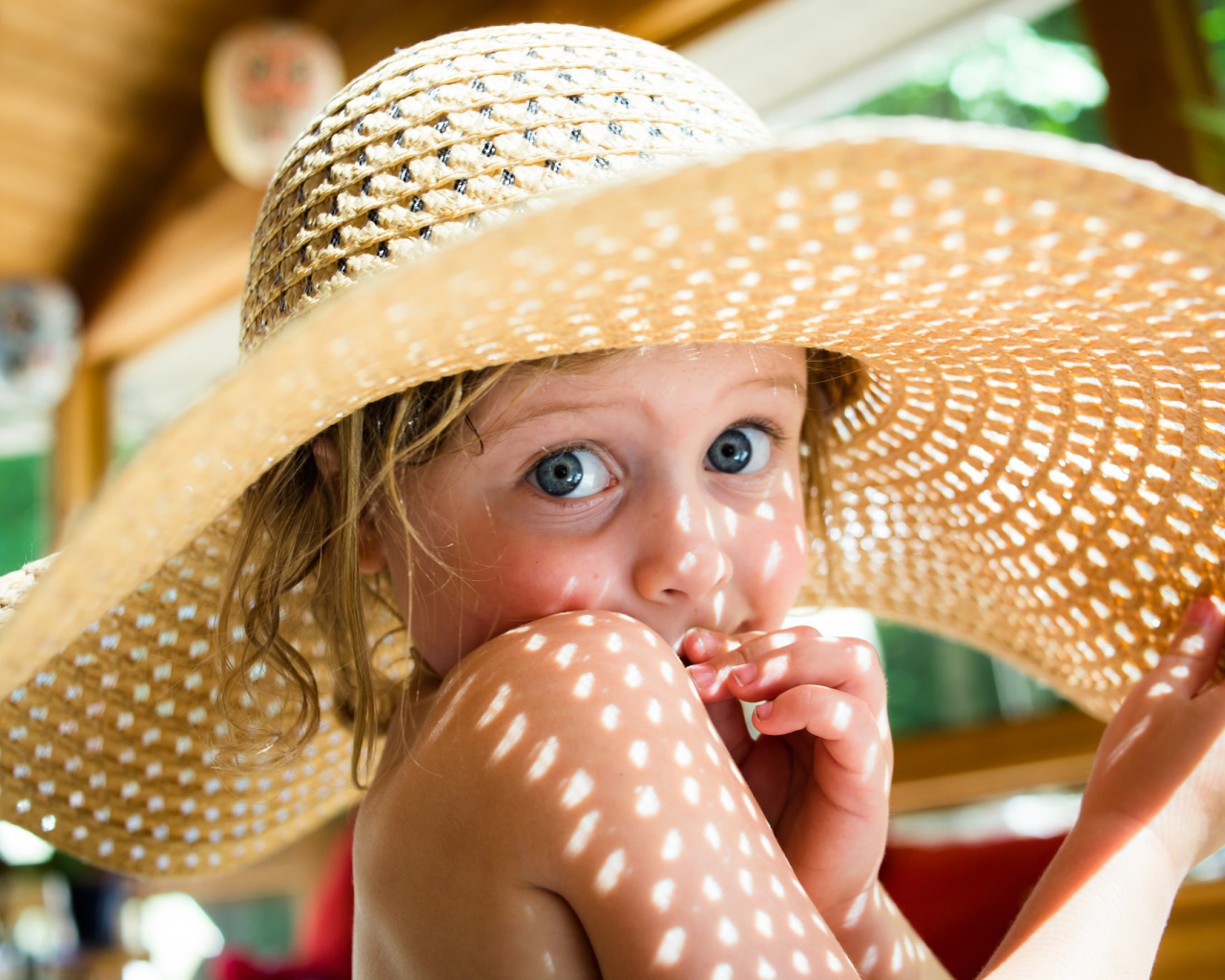Маленькая девочка в большой соломенной шляпе летом