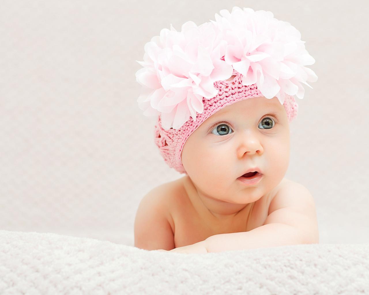 Маленькая девочка в вязаной шапке с цветами