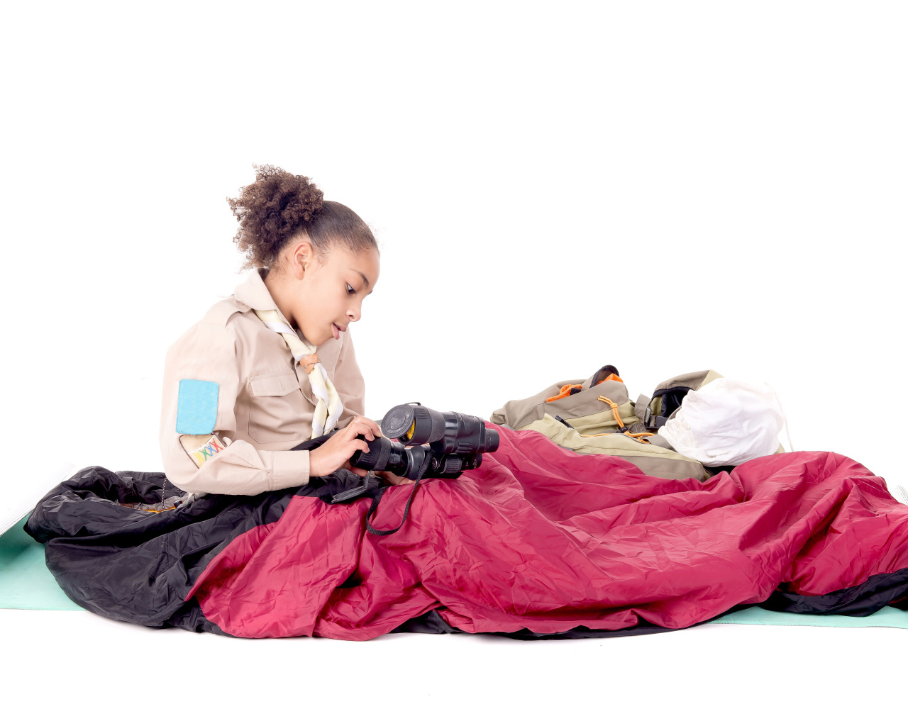 Маленькая девочка в спальном мешке с биноклем