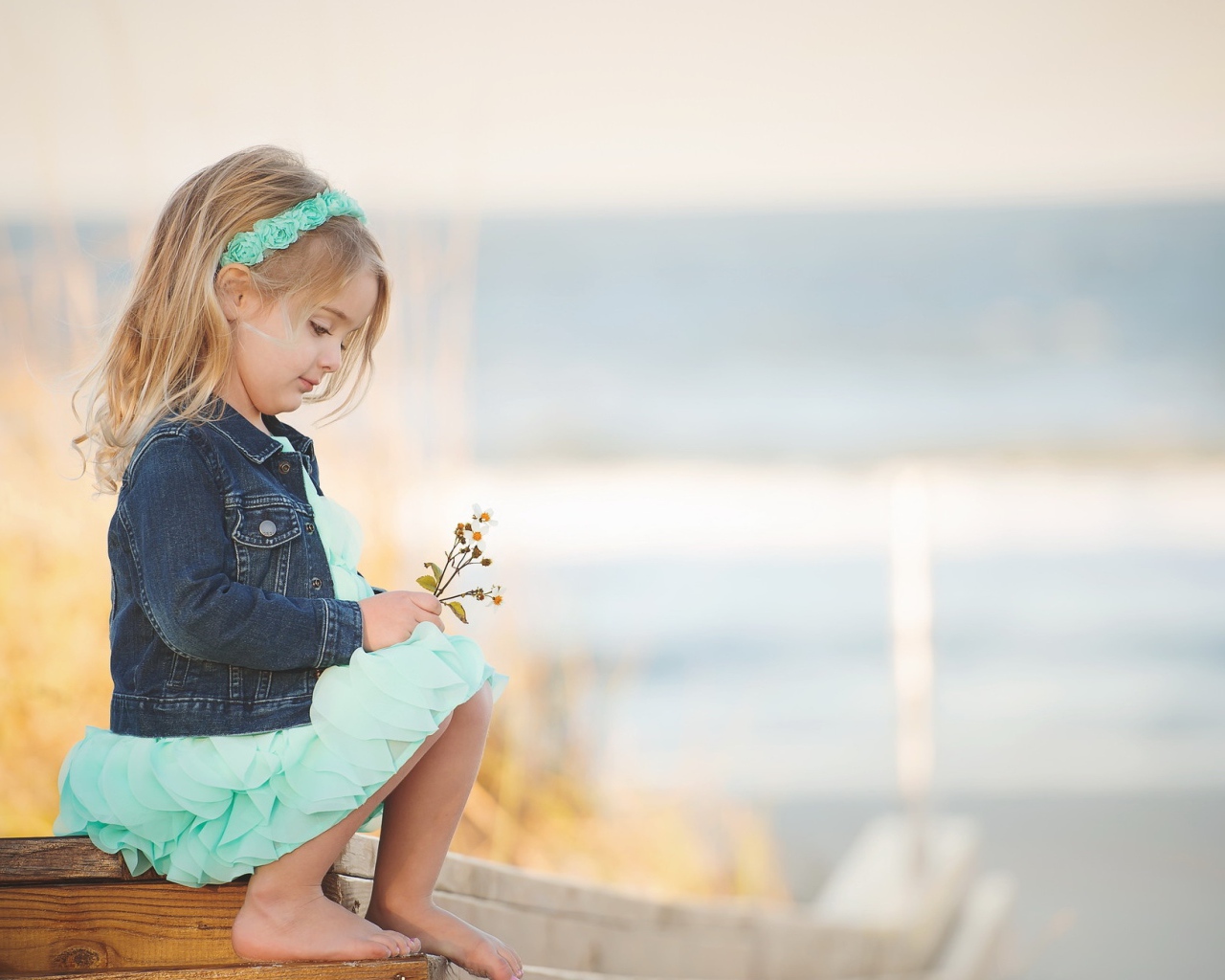 Маленькая девочка сидит на мосту