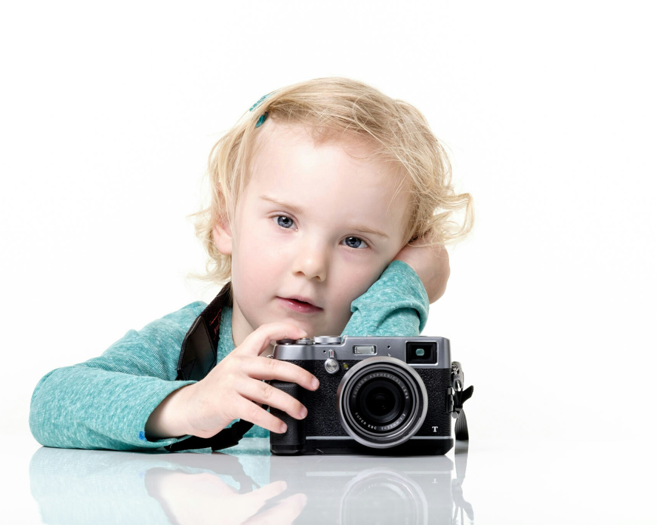 Маленькая девочка с фотоаппаратом на белом фоне
