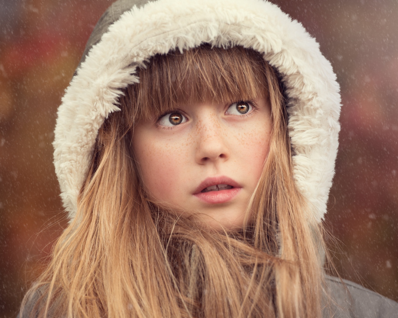 Маленькая девочка с веснушками на лице в капюшоне 