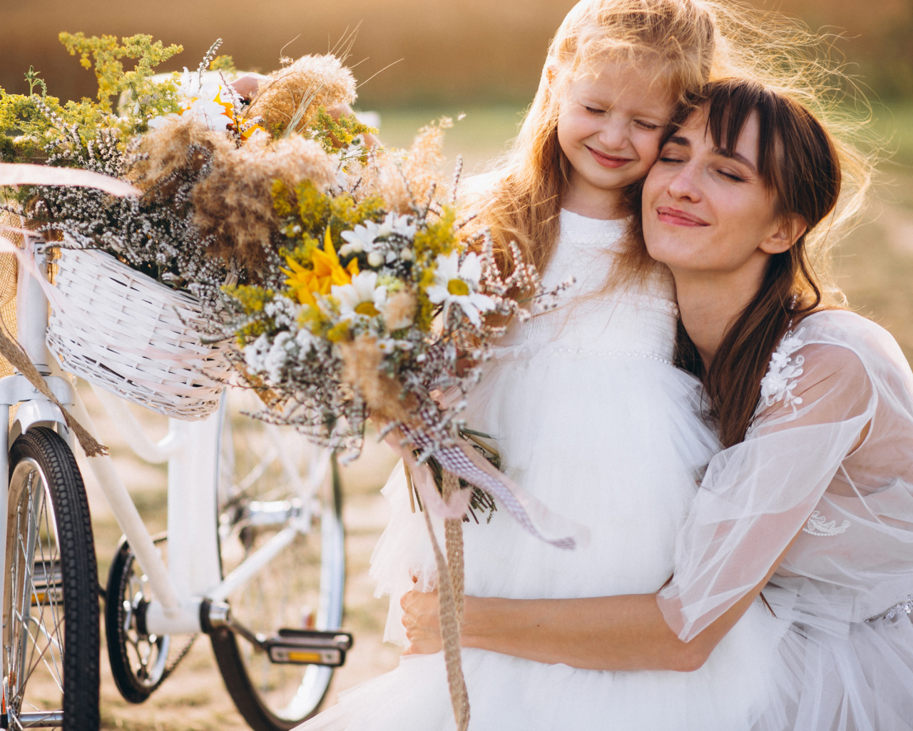 Маленькая девочка с мамой у велосипеда