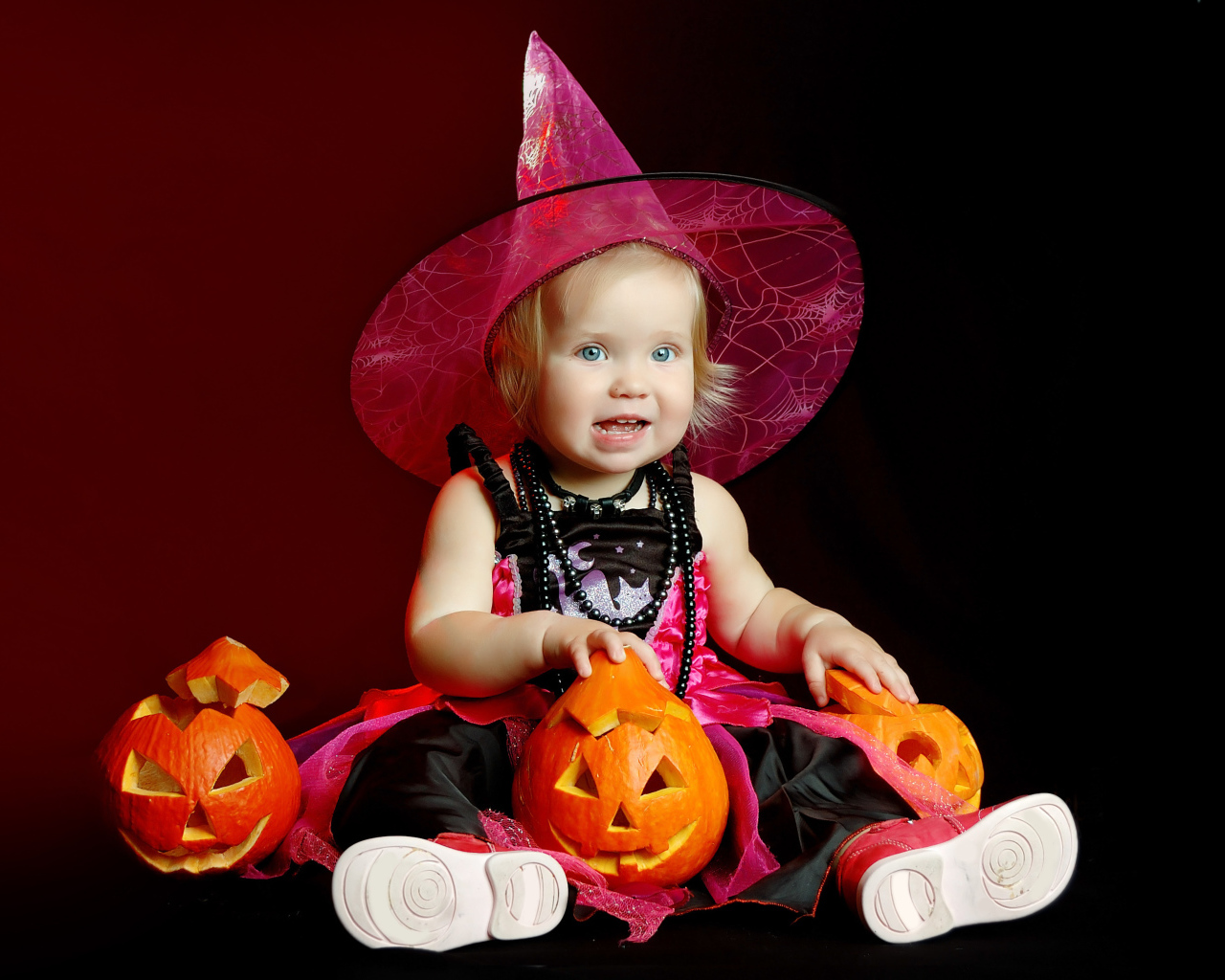 Маленькая девочка с тыквой в костюме на праздник Хэллоуин 