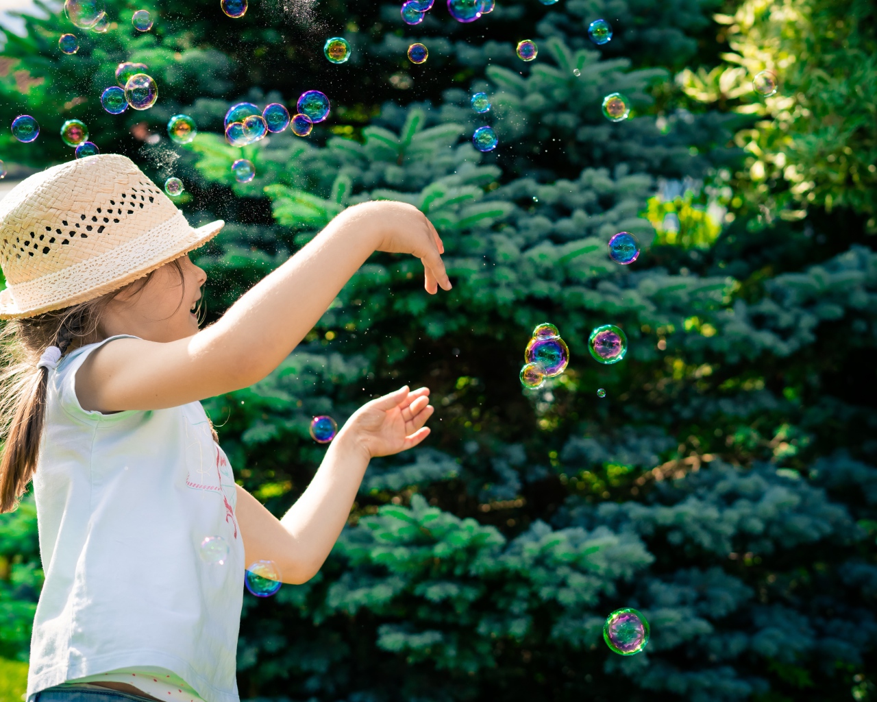 Маленькая девочка с мыльными пузырями у елки
