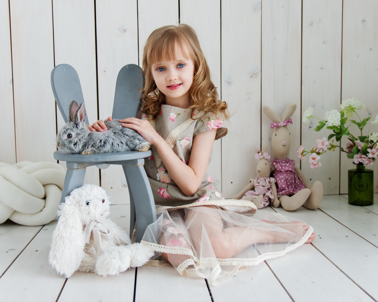Маленькая девочка с игрушками в комнате сидит на полу