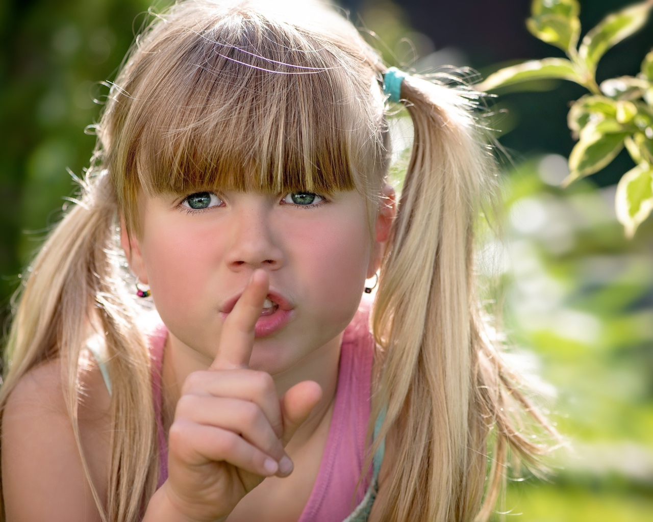 Маленькая зеленоглазая девочка с пальцем у рта 