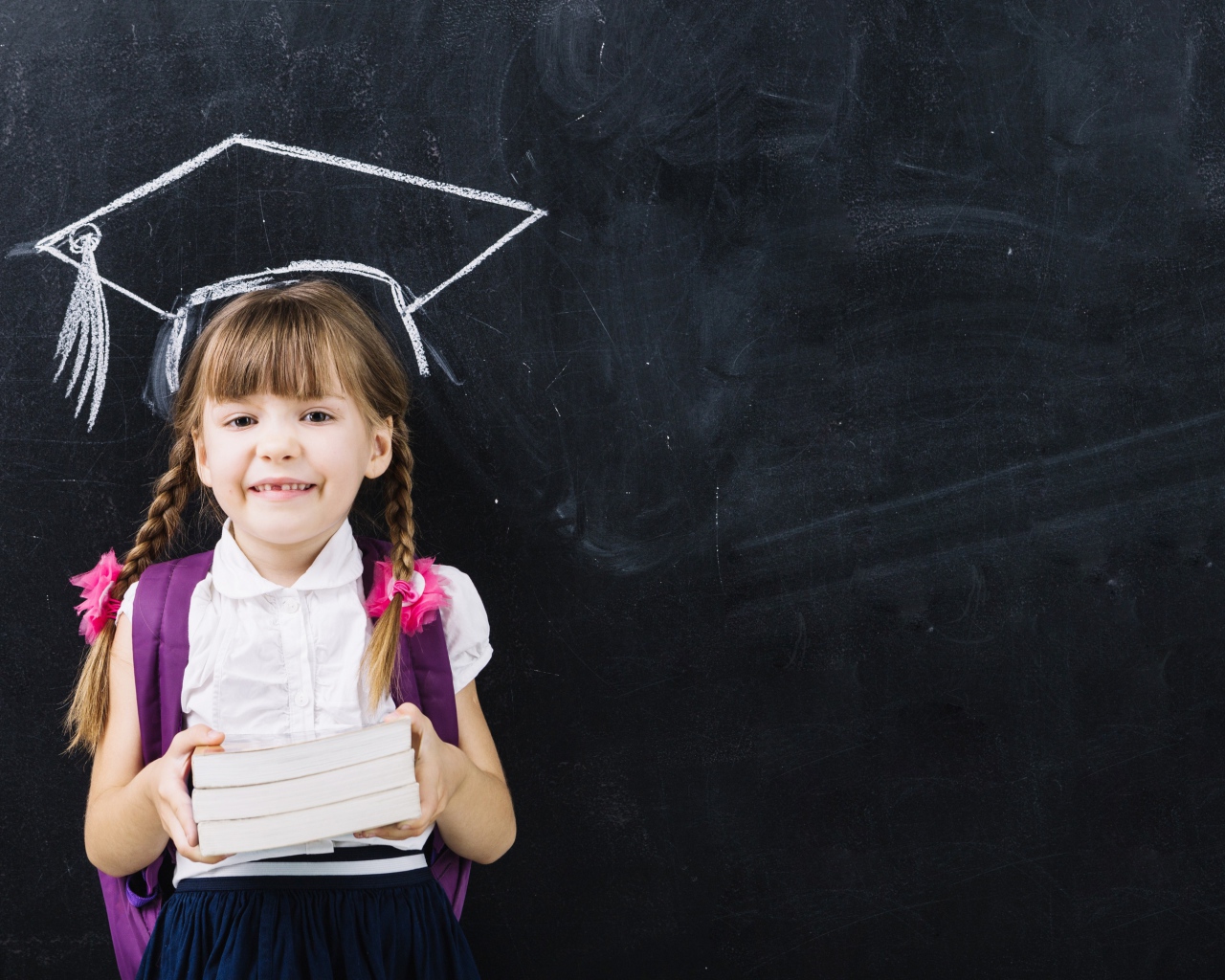 Маленькая школьница с книгами у доски 