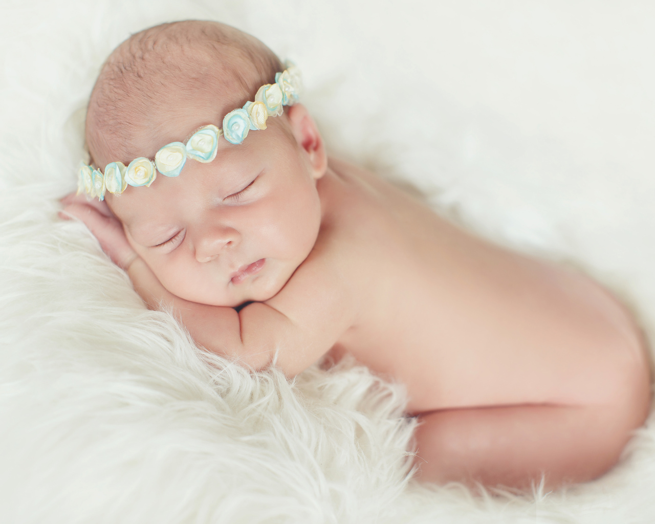 Маленький спящий ребенок на меховом покрывале