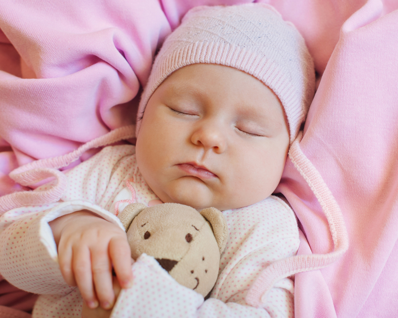 Спящий ребенок обнимает любимую игрушку