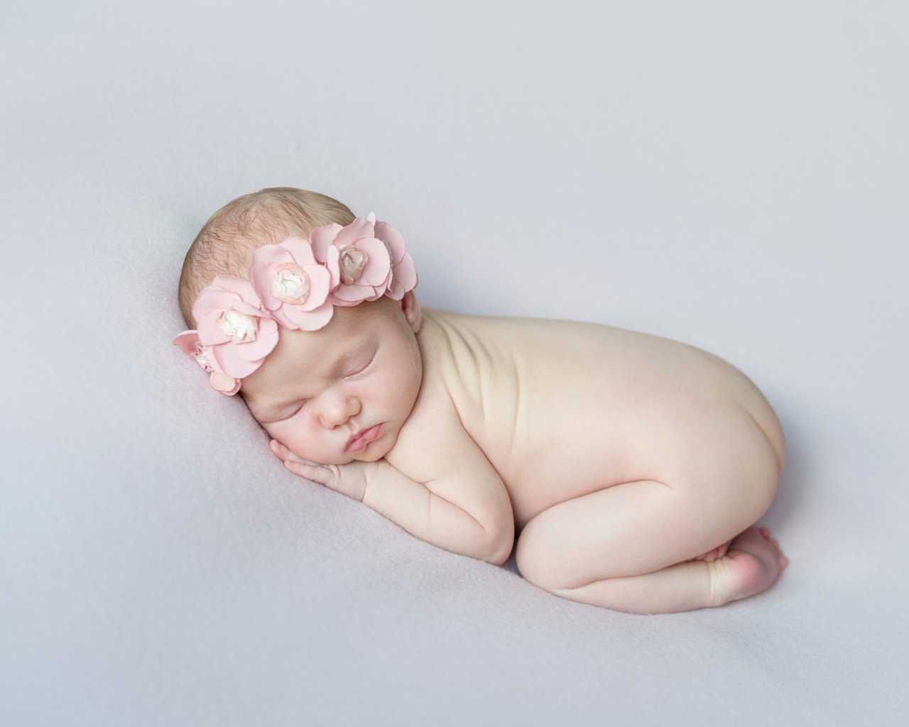 Спящая девочка с розовым венком на голове