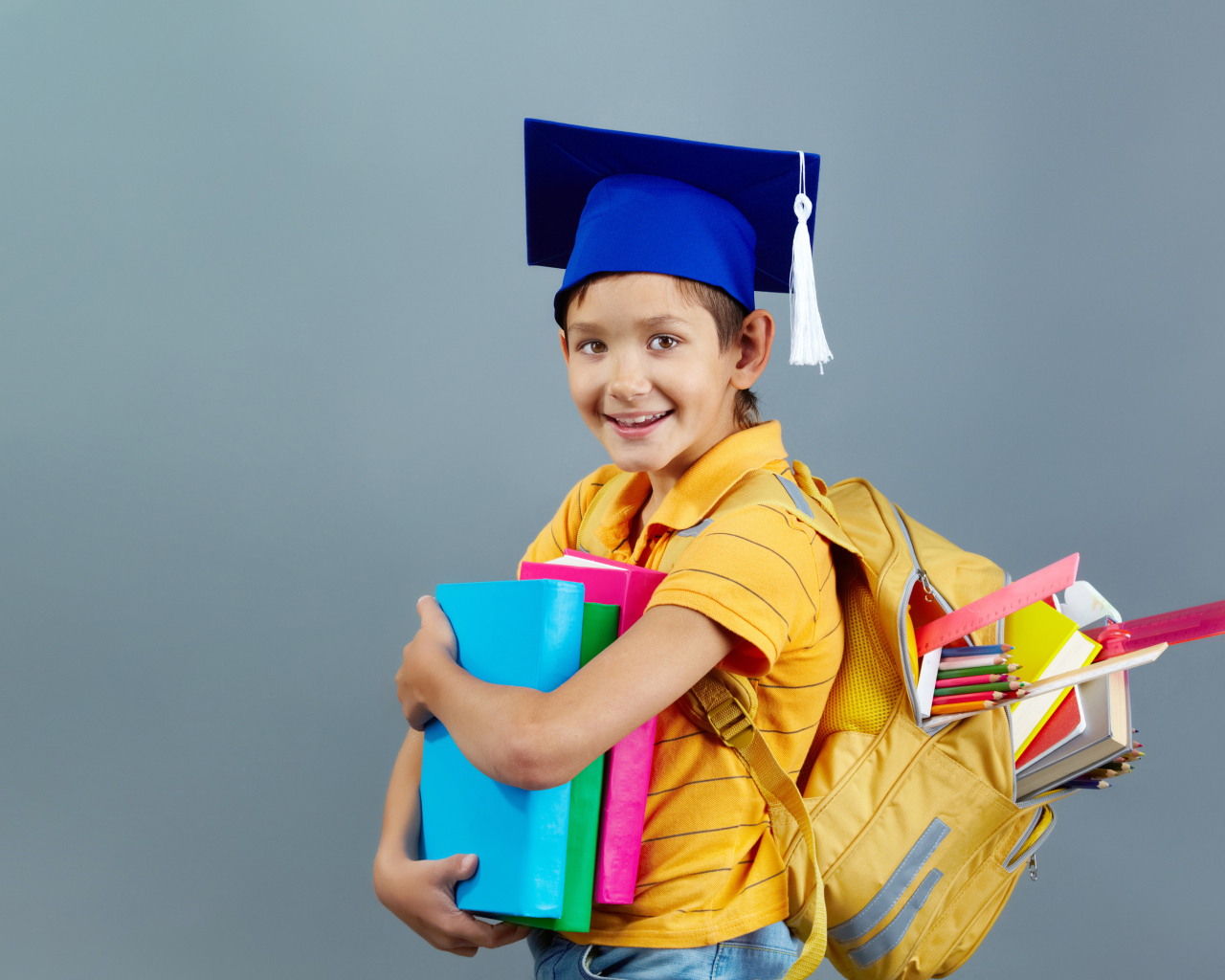 Умный мальчик школьник с рюкзаком  и учебниками