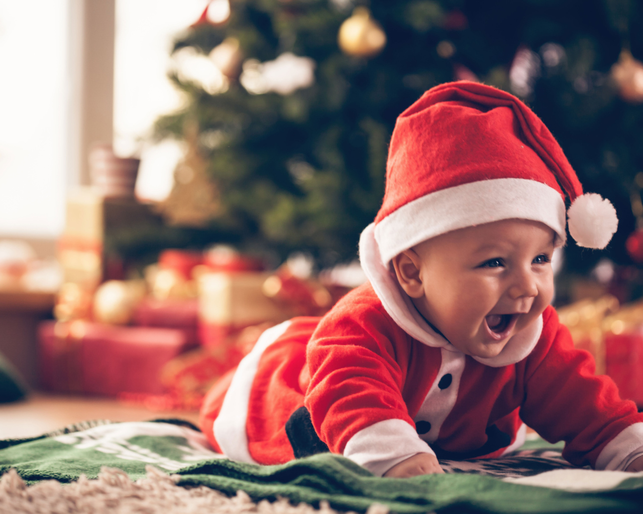 Улыбающийся малыш в новогоднем костюме у елки