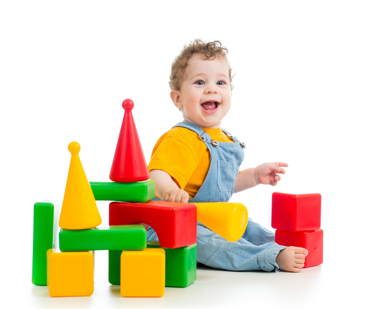 Улыбающийся милый малыш играет с кубиками на белом фоне