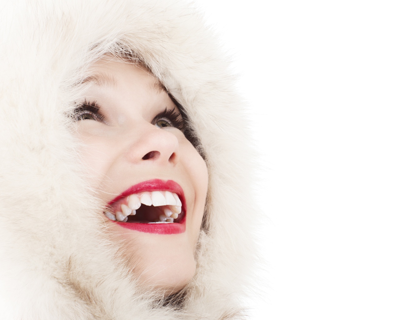 Улыбающаяся девушка в меховом капюшоне на белом фоне