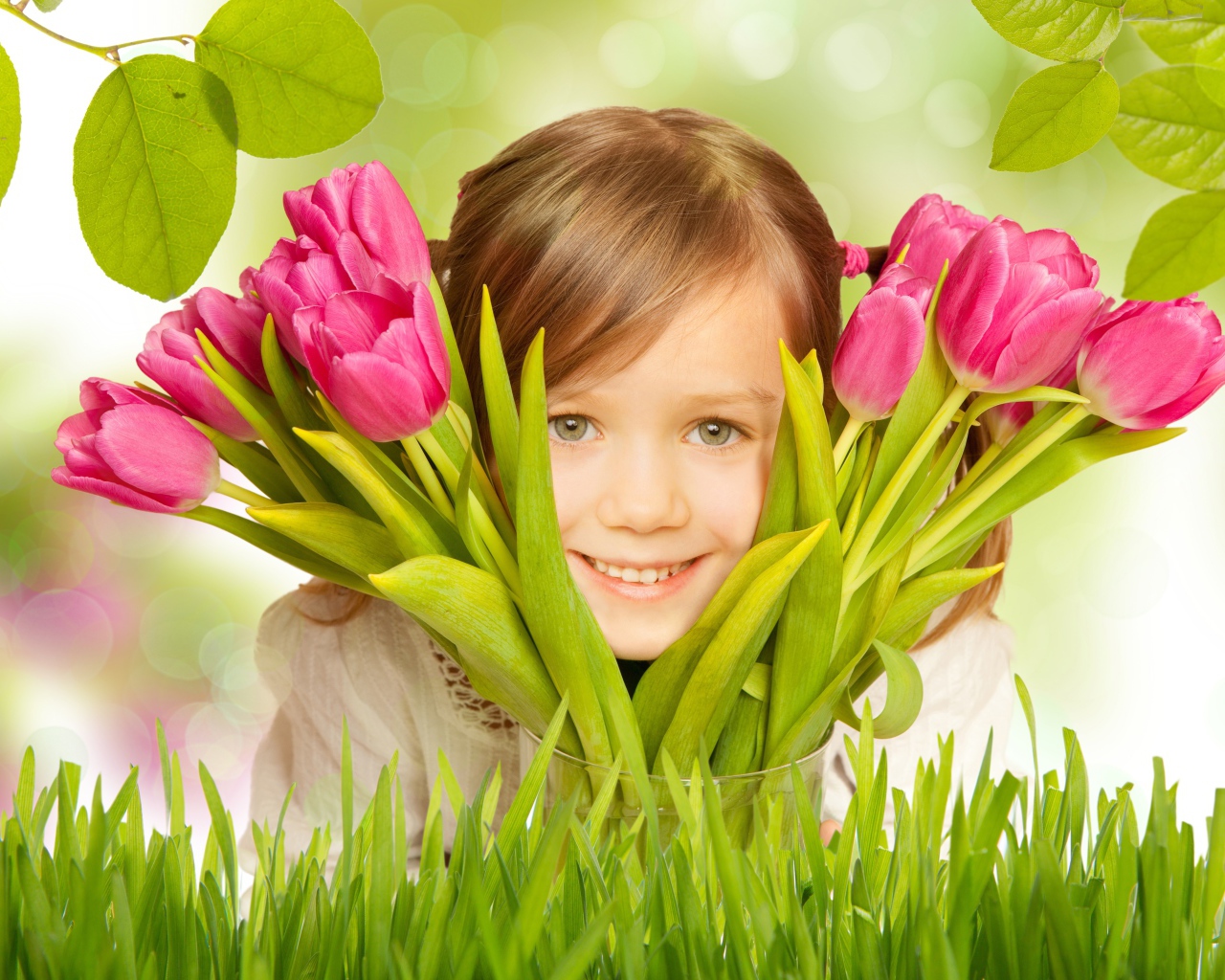 Улыбающаяся маленькая девочка с розовыми тюльпанами