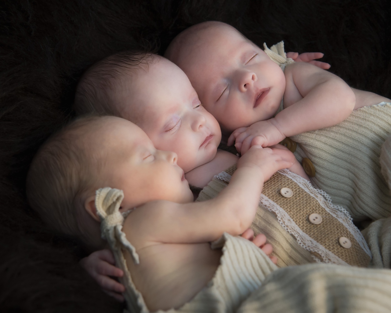 Три маленьких грудных ребенка спят обнявшись 