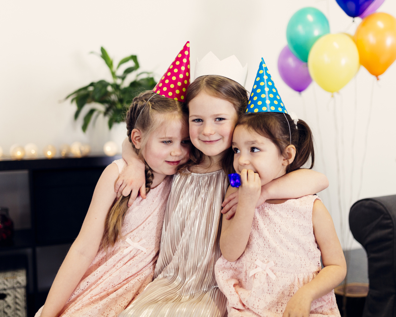 Три маленькие девочки в праздничных колпаках